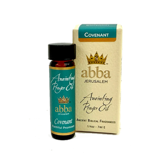 A small amber glass bottle of abba Jerusalem Anointing Prayer Oil next to its beige and teal packaging box, labeled Covenant.